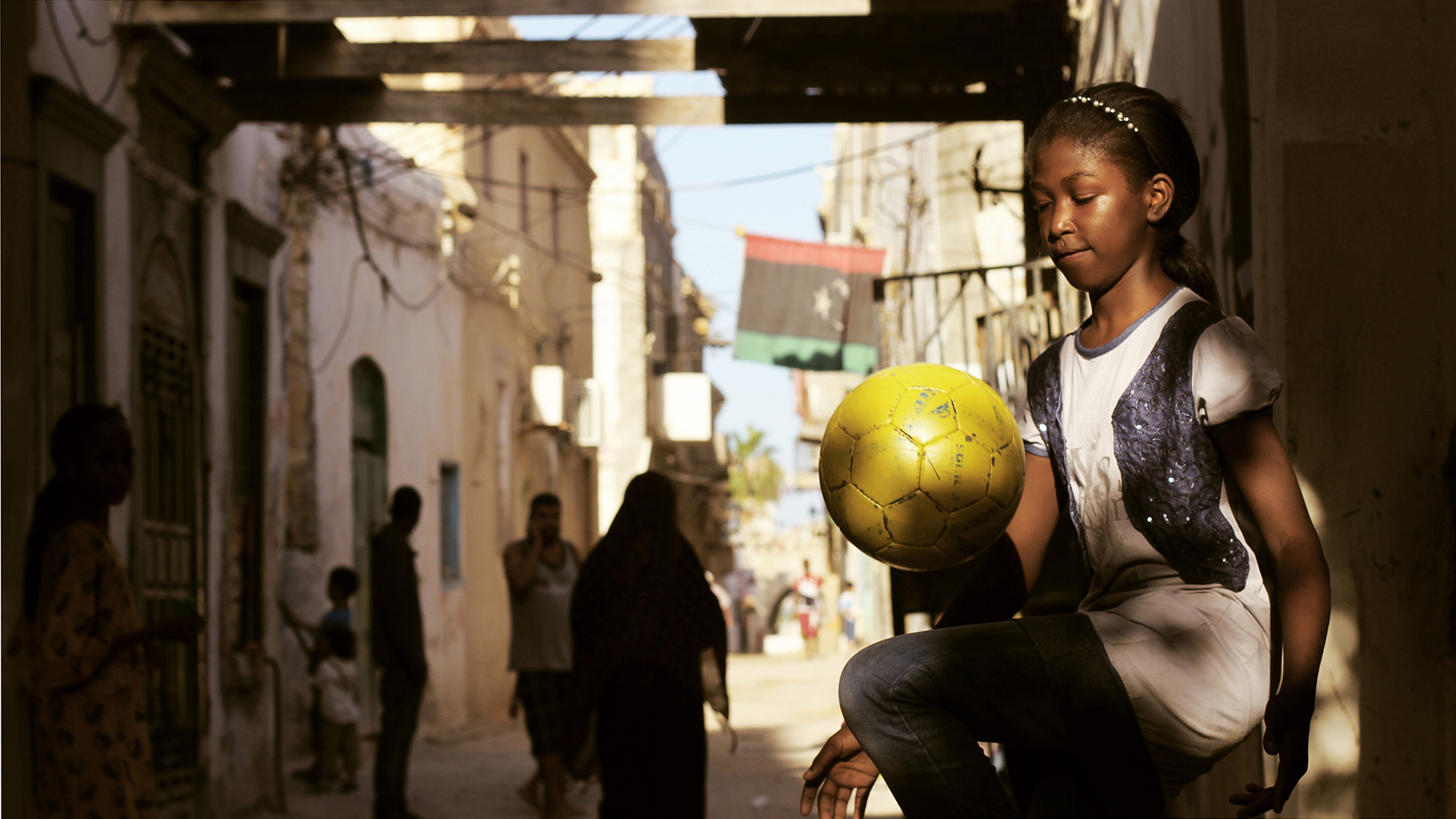 فتاة ليبية صغيرة تلعب كرة القدم في الشارع